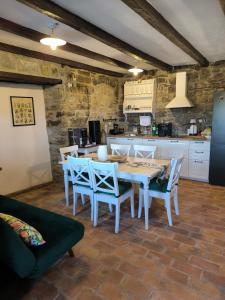 a dining room with a table and chairs and a kitchen at Vila EVANA in Sečovlje