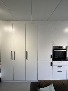 a living room with white cabinets and a microwave at Business Accommodation 'Comfort Living' in Geel +7 photos