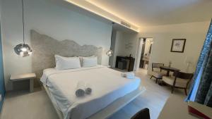 a bedroom with a large white bed with shoes on it at Casaliva Relais in Bardolino +52 photos