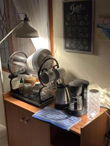 a kitchen counter with a coffee maker and pots and pans at The Station Hostel in Sathani Ayutthaya