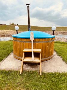 a wooden tub with a bench in front of it at Dom BAnia Mazury SPA in Kukowo +32 photos
