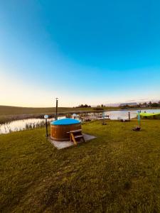 a field with a table and a boat in the grass at Dom BAnia Mazury SPA in Kukowo