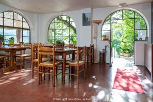 a dining room with a table and chairs and windows at Auberge du Point Sublime in Rougon