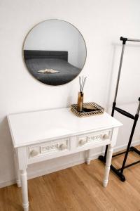 a white console table with a mirror on the wall at Schöne Wohnung mit Balkon in Vienna