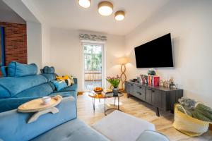 a living room with a blue couch and a flat screen tv at Widokówka 13 in Mikołajki
