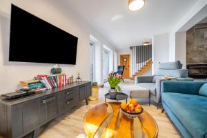 a living room with a large flat screen tv on a wall at Widokówka 13 in Mikołajki