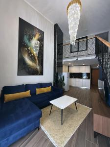 a living room with a blue couch and a table at Andor Luxury Hotel & Duplex in Durrës