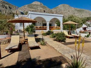 a patio with chairs and umbrellas in front of a building at Villa Evdokia in Kalymnos