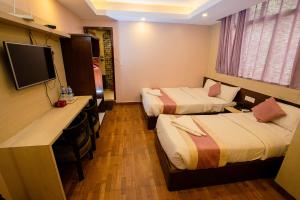 a hotel room with two beds and a flat screen tv at Rameshworam Hotel in Kathmandu