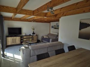 a living room with a couch and a tv at Port Griad in De Haan