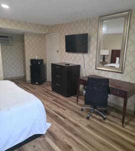 a hotel room with a desk and a bed and a computer at Dover Inn in Dover