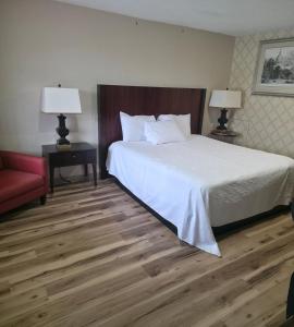 a hotel room with a bed and a red couch at Dover Inn in Dover