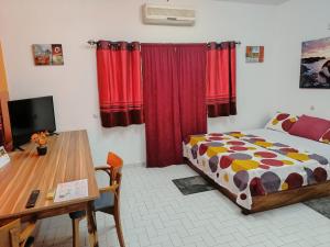 a bedroom with a bed and a desk and a table at Cloud9 Lomé in Lomé +26 photos