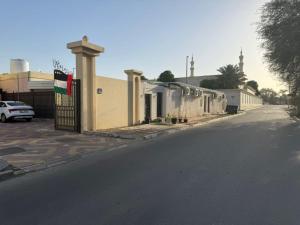a building with a flag on the side of a street at Bedroom Jimi in Al Ain +2 photos
