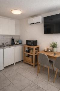 a kitchen with a table and a sink and a microwave at Deniz Apartments in Kappel-Grafenhausen