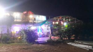 a lit up building with lights on it at night at Bhogwal farm house in Karjat