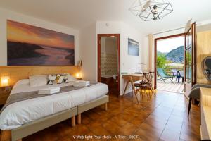 a bedroom with a large bed and a balcony at Auberge du Point Sublime in Rougon