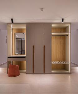 a room with wooden doors and a orange stool at Med IL Caesar ADULT ONLY in Zāwiyat al ‘Awwāmah