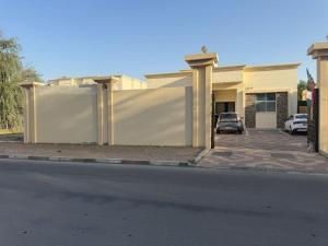 a house with a fence next to a parking lot at Separate studio jimi in Al Ain