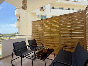a patio with two chairs and a table on a balcony at Coastal 2BR Apt in Mackenzie Steps from Beach by Cyprus Horizons in Scala