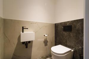 a bathroom with a toilet and a sink at Above Danube - Luxury Apartment in Vienna +16 photos