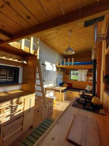 a large kitchen with wooden cabinets and a staircase at La tiny house Low Tech in Cléder