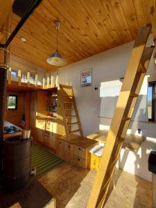 a room with a wooden ceiling and a staircase at La tiny house Low Tech in Cléder
