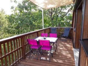 a deck with pink chairs and a table on it at Chalet Z en Alsace in Barr