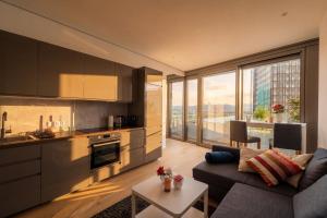 a kitchen and living room with a couch and a table at Above Danube - Luxury Apartment in Vienna