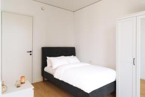 a white bedroom with a bed and a mirror at Above Danube - Luxury Apartment in Vienna