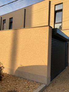 a building with a garage with a door at Luxe House Odessa Private Jacuzzi BBQ, Free Parking in Odesa