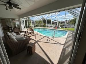a living room with a view of a swimming pool at Salted Sunset at Punta Gorda Isles in Punta Gorda