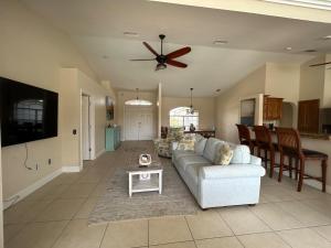a living room with a couch and a ceiling fan at Salted Sunset at Punta Gorda Isles in Punta Gorda