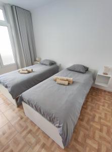 two beds sitting next to each other in a bedroom at Refúgio Machiquense in Machico