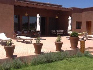 a patio with umbrellas and plants inront of a building at Domaine VILLA in Tameslouht