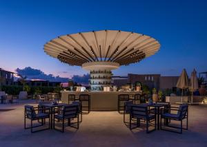 a patio with tables and chairs in front of a fountain at Med IL Caesar ADULT ONLY in Zāwiyat al ‘Awwāmah