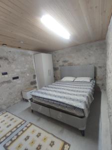a bedroom with a bed in a stone wall at Begonvil Evleri Karaburun in Karaburun