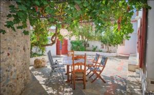 a wooden table and chairs in a courtyard with a tree at Trifillianika Traditional House in Trifilliánika