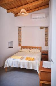 a bedroom with a bed and a wooden ceiling at Trifillianika Traditional House in Trifilliánika