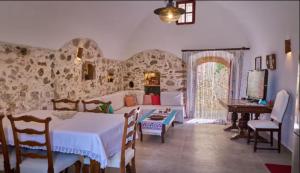a living room with a table and a room with a couch at Trifillianika Traditional House in Trifilliánika