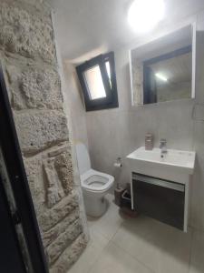 a bathroom with a white toilet and a sink at Begonvil Evleri Karaburun in Karaburun +82 photos