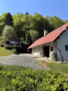 a white building with a red roof and a driveway at Secret Forest Retreat in Ptujska Gora