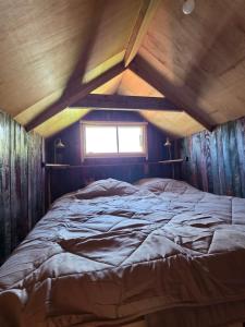 a large bed in a room with a window at Ardennen Kotje in Durbuy