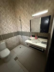a bathroom with a sink and a toilet and a mirror at Single room Jimi in Al Ain +15 photos