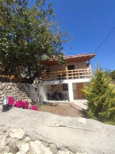 a house with a stone wall and a building at Begonvil Evleri Karaburun in Karaburun