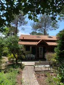 a house with a bench in front of it at Maison Maubuisson proche du lac de Carcans in Carcans