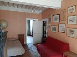a living room with a red couch and a bed at Maison Corbigny in Corbigny