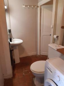 a bathroom with a white toilet and a sink at Maison Corbigny in Corbigny +7 photos
