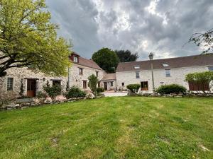 a large house with a grass yard in front of it at Le Merisier in Épieds
