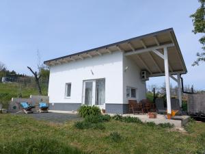 a white house with awning in a yard at Csipkeház Kisapáti in Kisapáti